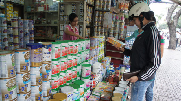 Lựa chọn mua sữa cho con tại một cửa hàng ở quận 3, thành phố Hồ Chí Minh.